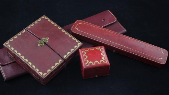 Three assorted early 20th century Cartier jewellery boxes and a pouch.